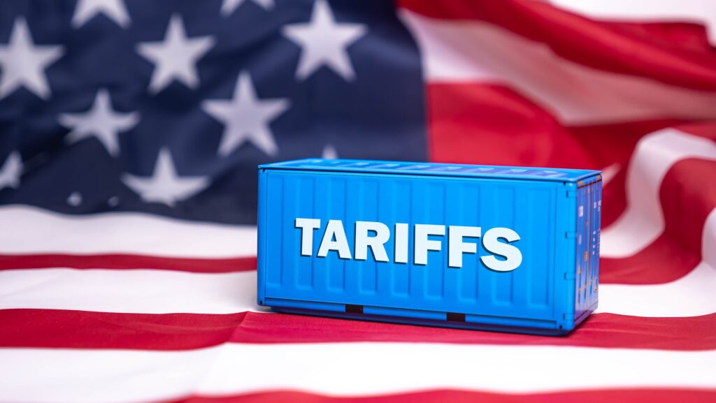 Contenedor azul con la palabra Tariffs sobre la bandera de Estados Unidos, representando los aranceles de Trump